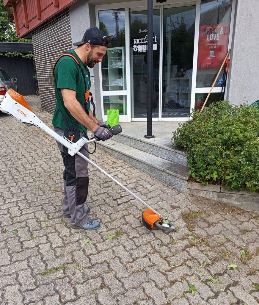 Jochen arbeitet mit dem Stihl-Akku-Freischneider an einem gepflasterten Weg